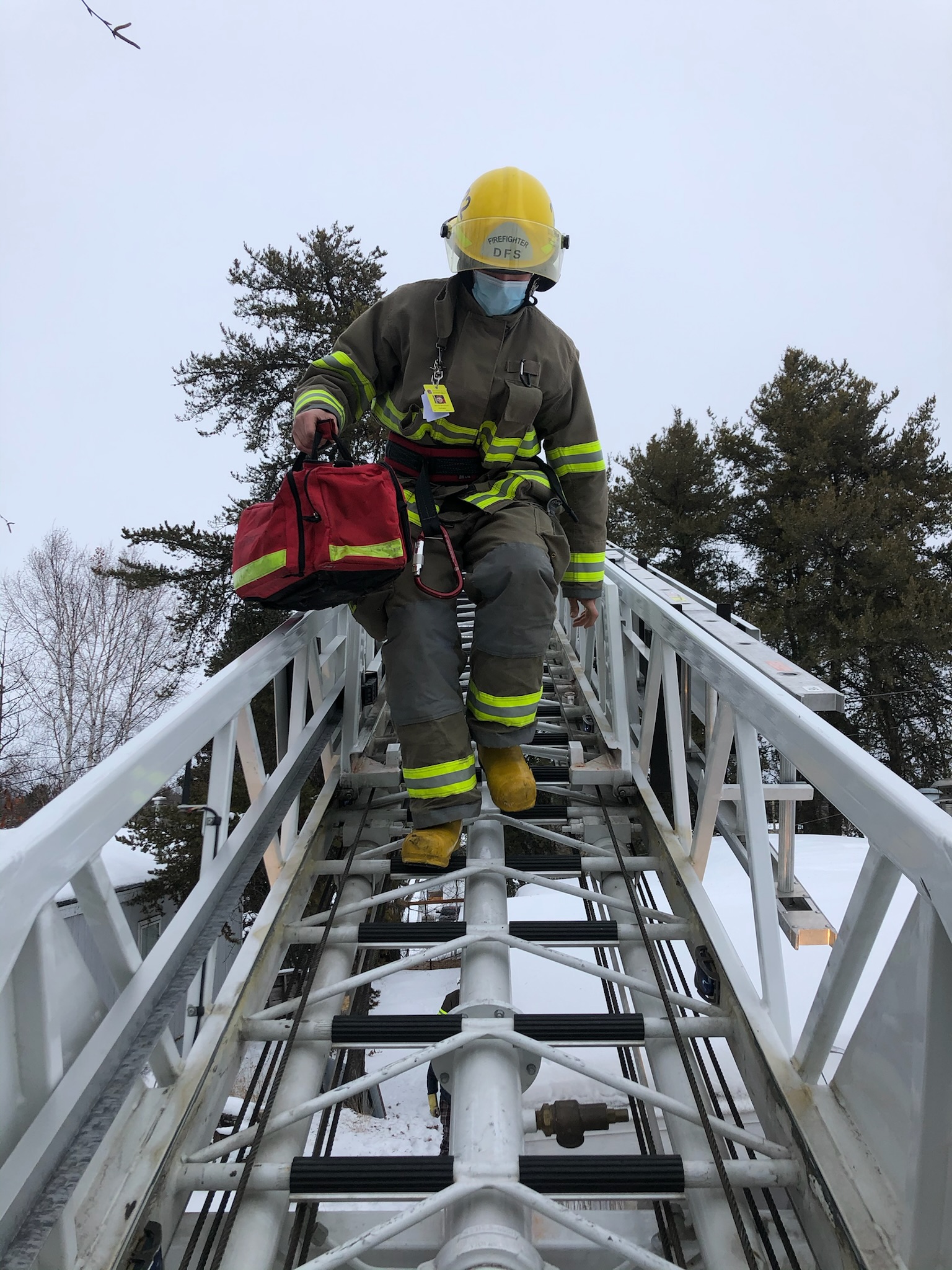 Firefighter climbing down an aerial ladder