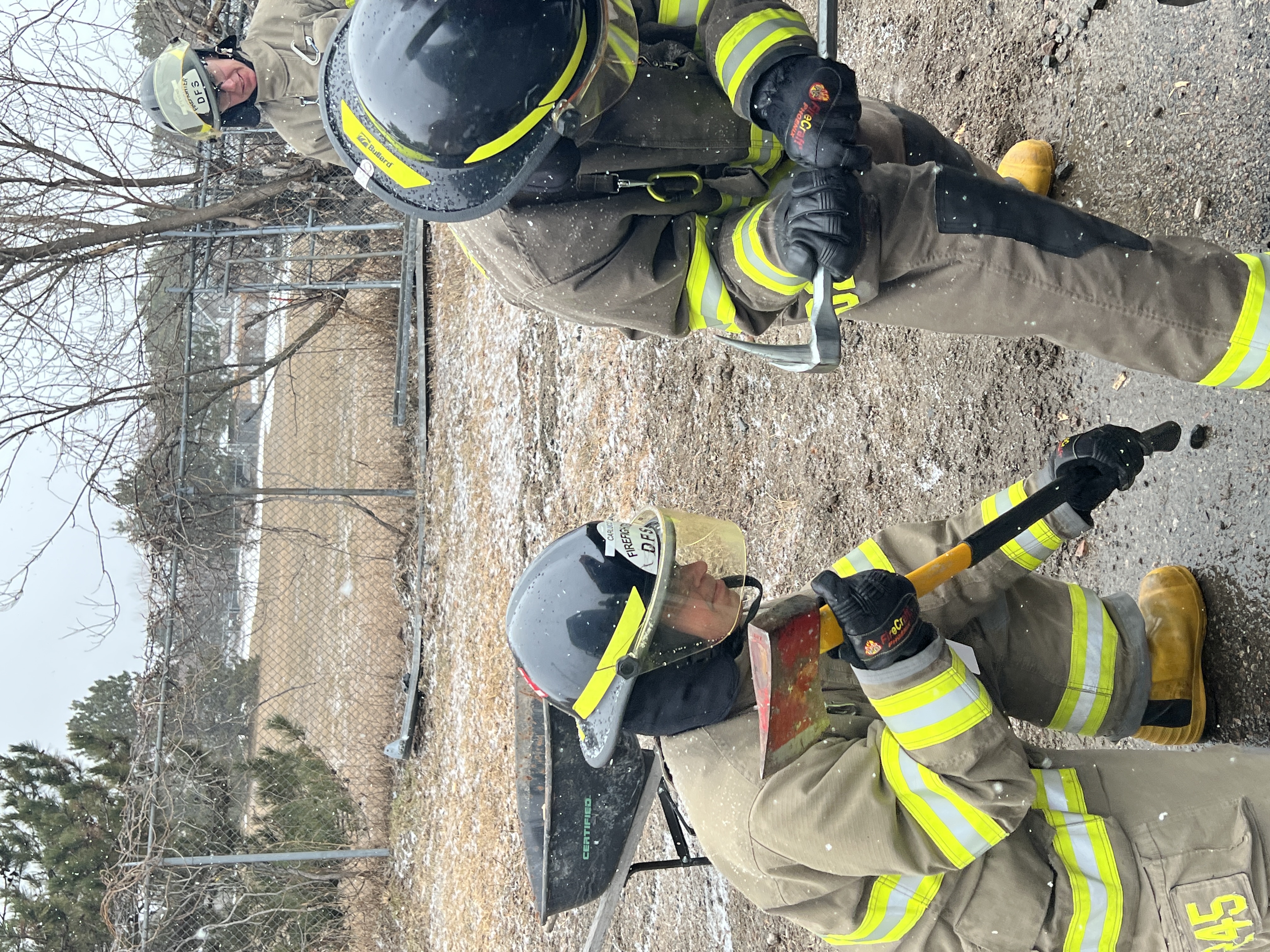 Firefighters forcing entry on a forcible entry door prop
