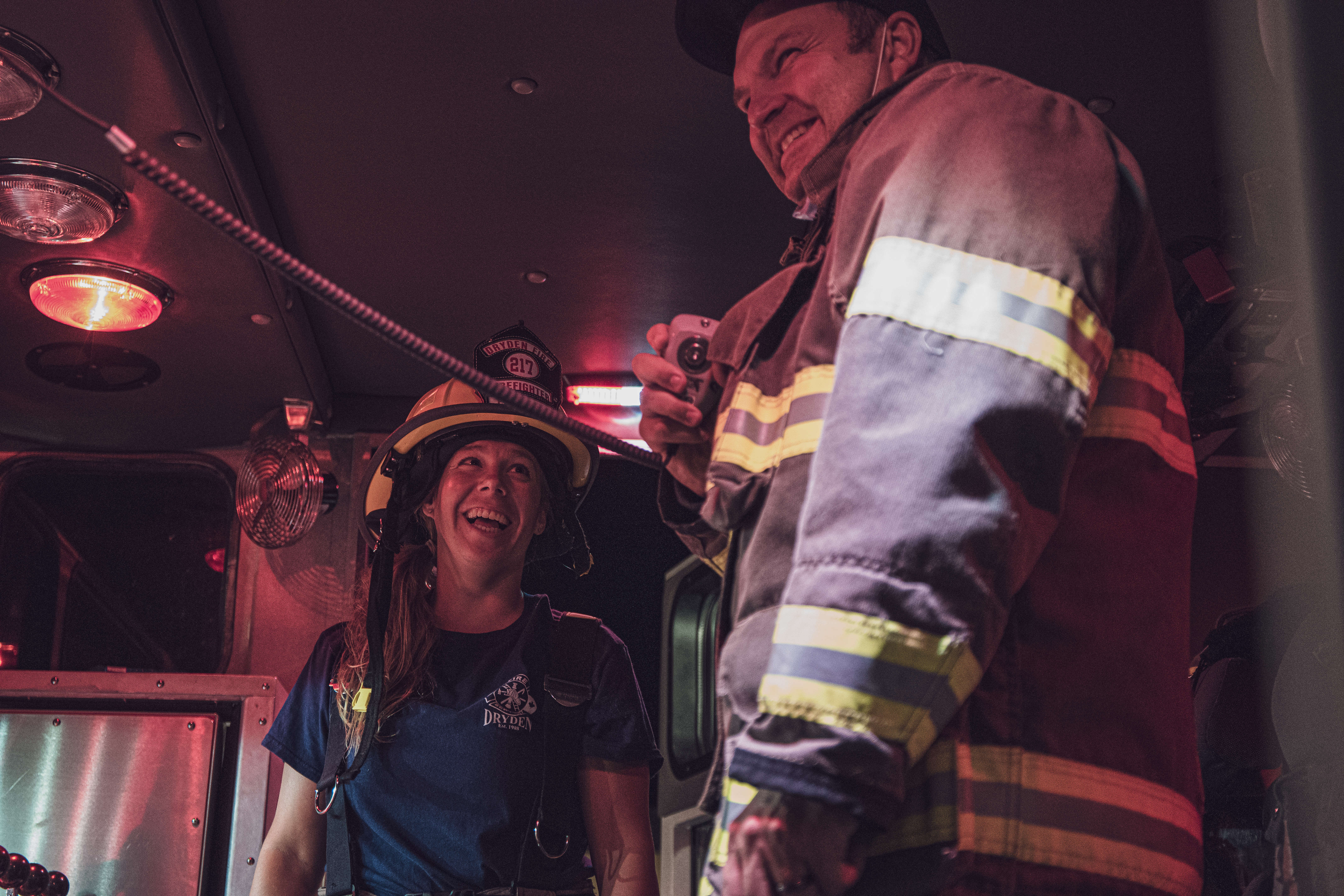 Firefighters standing in the back of a Fire Apparatus on the radio